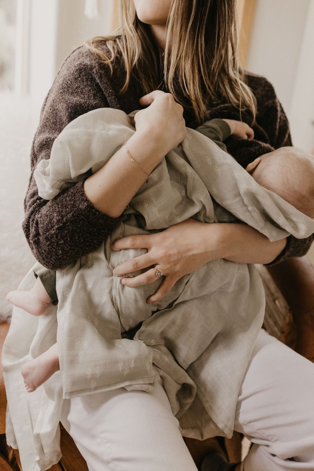 a mother soothing her baby, holding a baby boy against her chest
