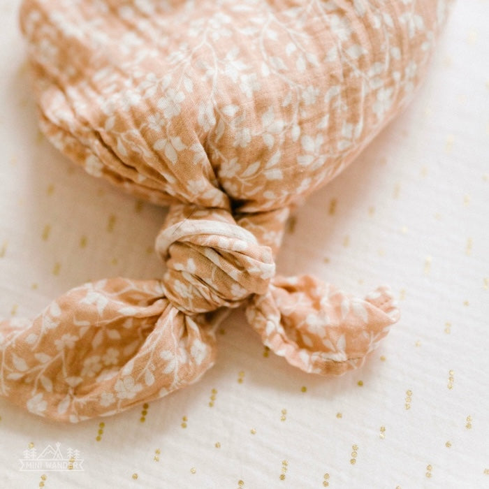 pink baby blanket tied in a knot like a mermaid tail