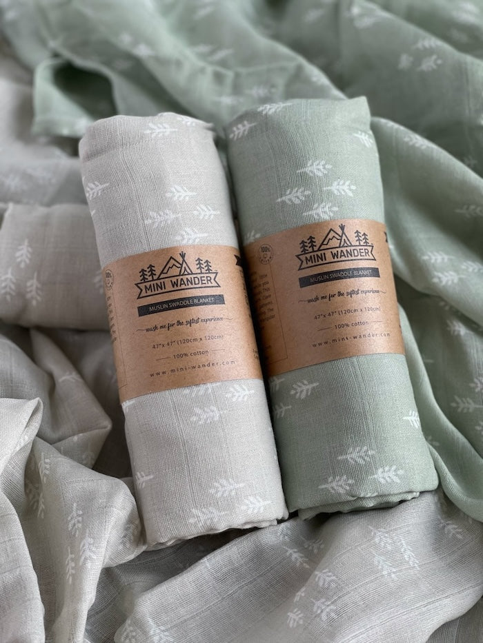Photos of the two newborn swaddle set and the perfect christmas swaddle rolled and packaged using The Mini Wander kraft paper and logo