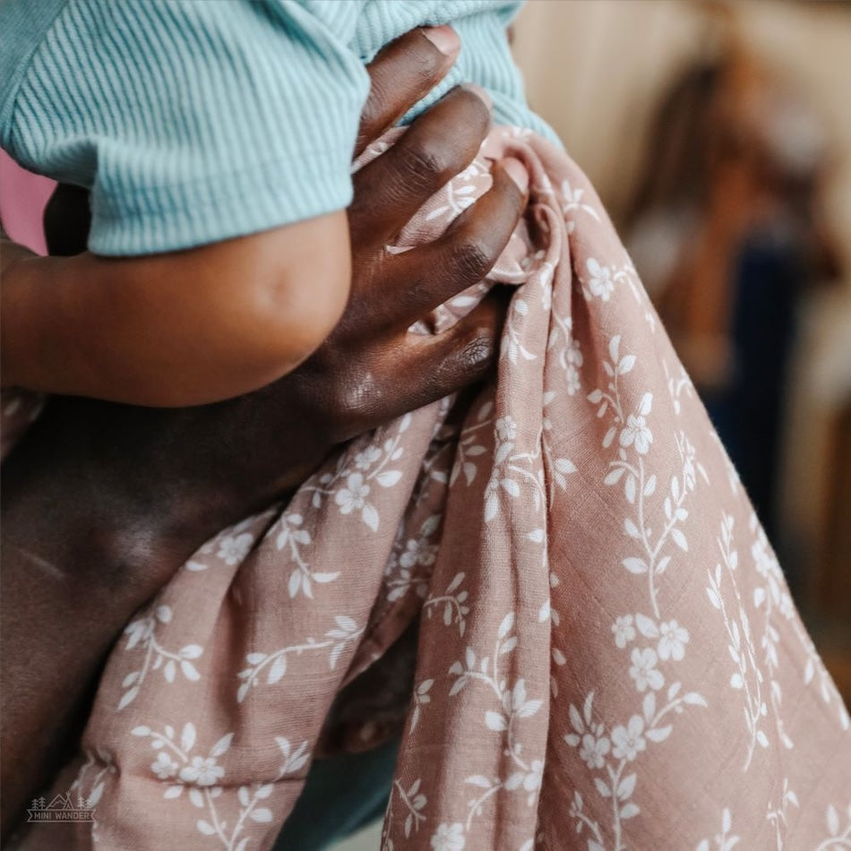 photo of the hand holding a baby while wrapped in a bloom sienna swaddle from Mini Wander