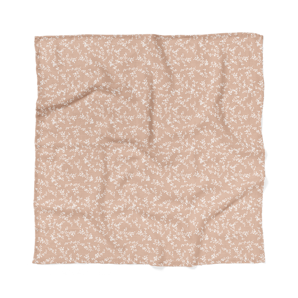 bloom peach swaddle laid flat showing the pretty bloom patterns that work perfectly as a cute summer blanket for your baby