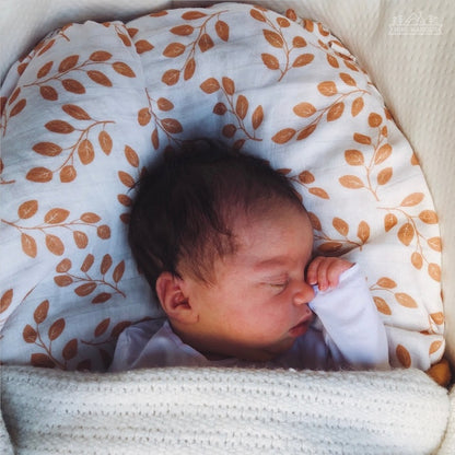 sweet baby boy sleeping with the cotton infant summer swaddle amber leaves print used as a pillow cover