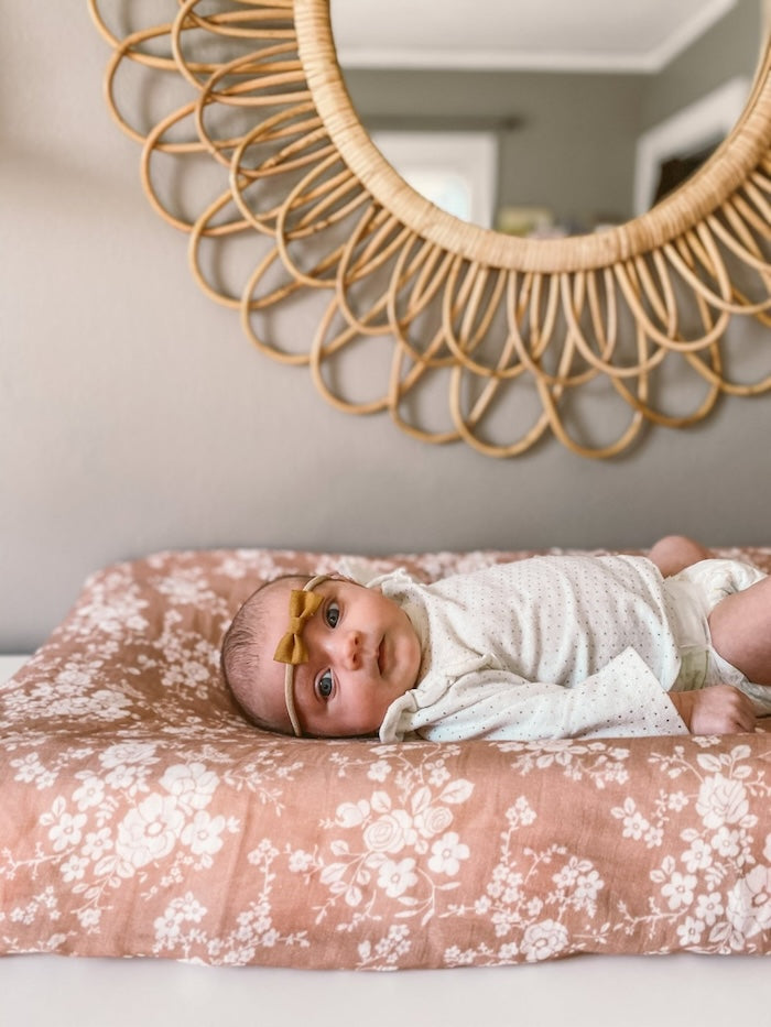 A Baby on a nicely laid swaddle with vintage floral design.
