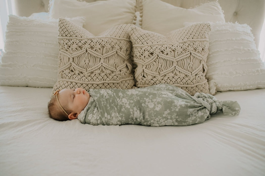 cute baby girl sleeping soundly wrapped in her vintage bouquet green baby blanket
