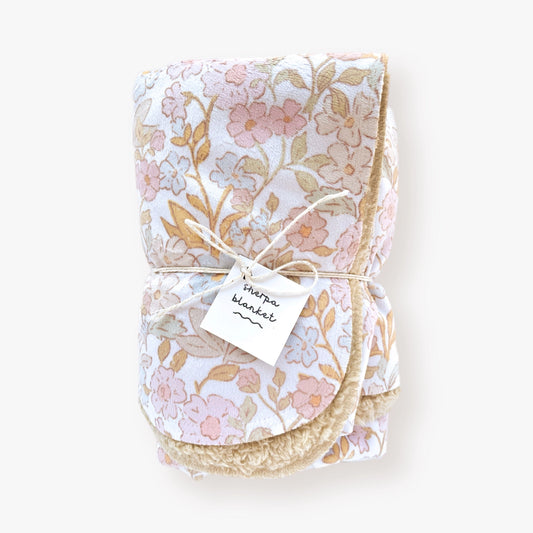 Infant sherpa blanket with Candyland Floral patterned minky front, light brown sherpa backing, displayed.