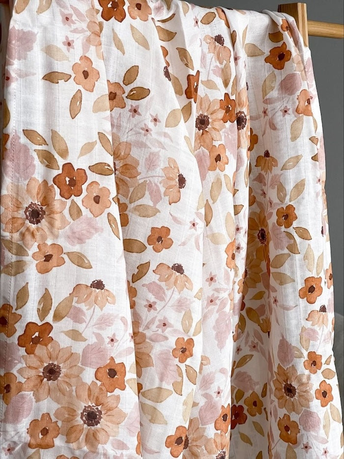 sunflower baby blanket hanged in a wooden clothes rack showing the sunflowers and leaves making htem the perfect baby girl blankets