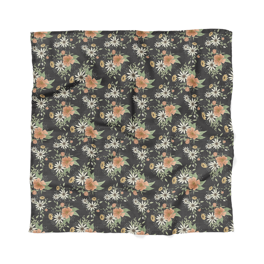 a photo of our spring blossom charcoal gray cotton swaddle laid flat showing the entire print of daisies, peonies and more