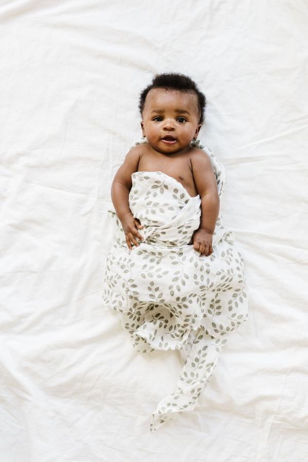 baby boy wrapped in a leaves sage green with white background. Leaves sage green is part of the baby boy newborn set
