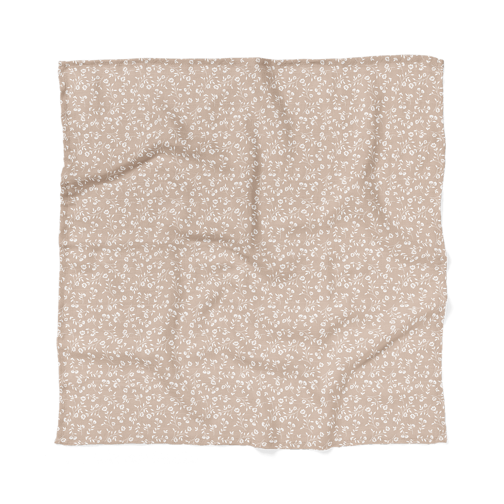 The Mini Wander wild flower taupe floral baby blanket displaying how big it is which makes it a perfect baby wrap on how to swaddle a baby