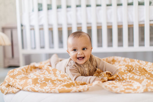 baby boy using a muslin blanket as a floor cover