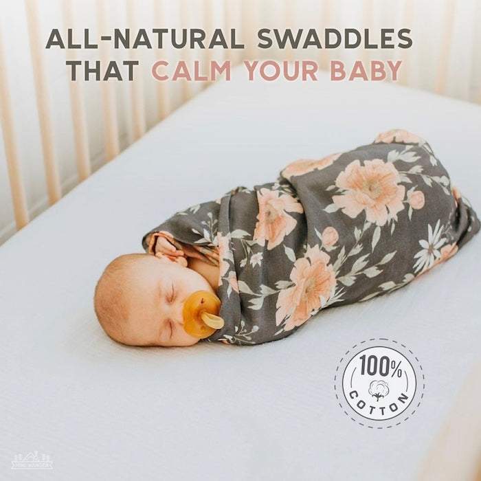 infographic that says all natural swaddles that calm your baby with a baby in the crib background sleeping wrapped in the peony bloom charcoal gray 