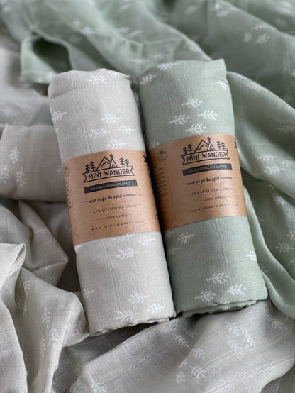 Photos of the two newborn swaddle set and the perfect christmas swaddle rolled and packaged using The Mini Wander kraft paper and logo