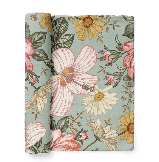 A swaddle made of a garden bouquet of daisies, roses, and creamy pink hibiscus with a sea foam colored background, one of mini wander's best-selling swaddles.