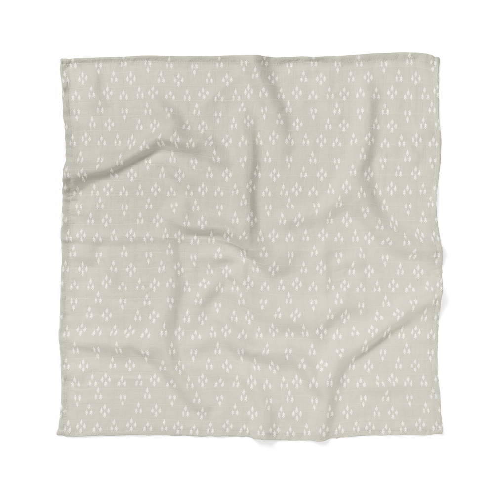 our forest swaddle laid flat showing the tiny trees in triangular pattern making it the perfect christmas swaddle