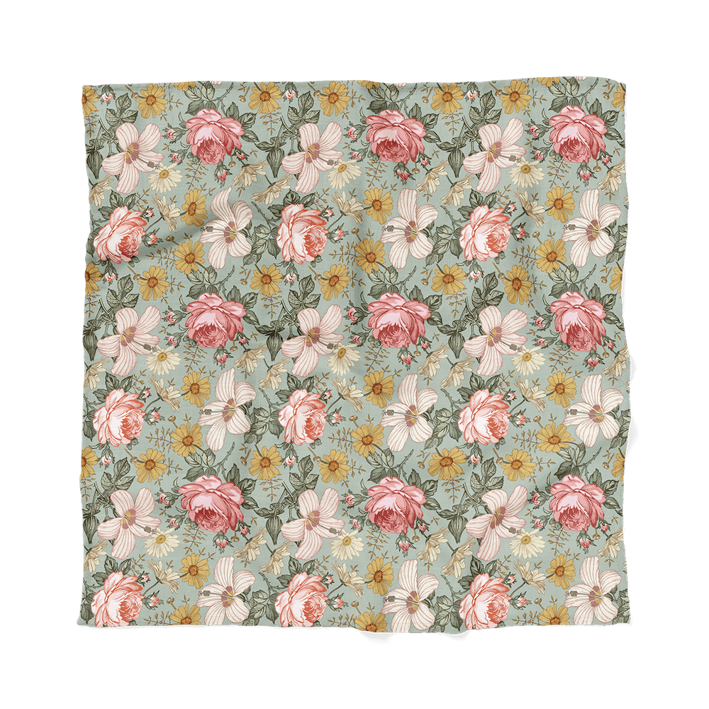 Flatlay of Mini Wander garden floral sea foam featuring daisies, roses and creamy pink hibiscus, this rich pattern adds a unique touch to your baby’s nursery.