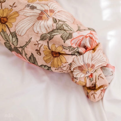 Pink Floral swaddle tied in a mermaid tail knot for newborn photoshoot.