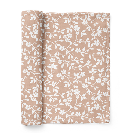half rolled pink swaddle blanket in the magnolia tree design