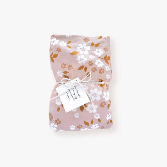 Jersey polyester cover with whimsy floral pattern in white and beige flowers, dark orange leaves on a dusty pink backdrop