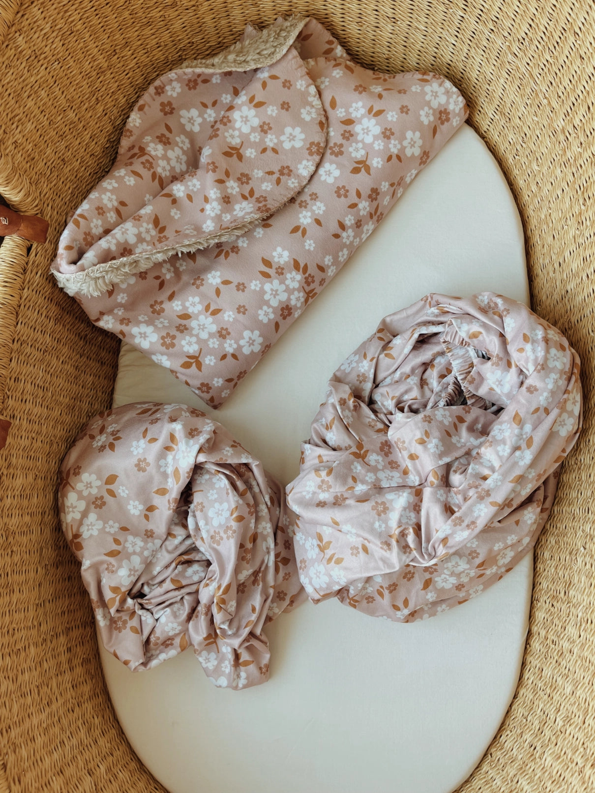 crib sheet set with whimsy small white florals on a pink back drop.