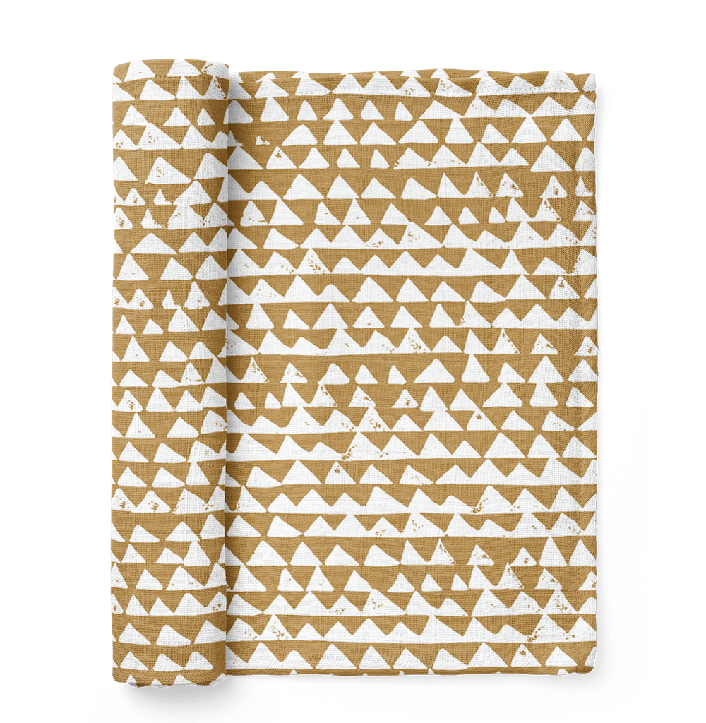 mountain swaddle in the color honey gold with a checkered triangle pattern