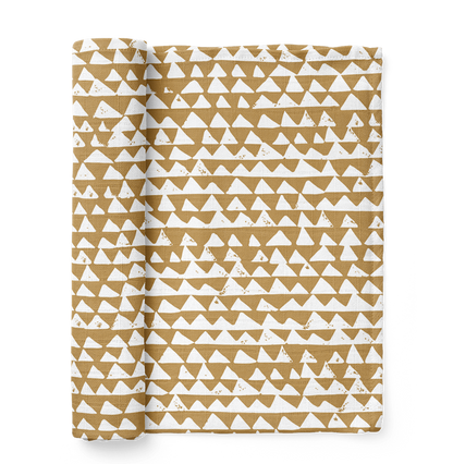 mountain swaddle in the color honey gold with a checkered triangle pattern