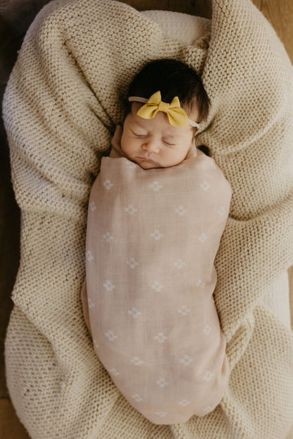 sleeping baby girl wrapped in a pastel pink baby blanket