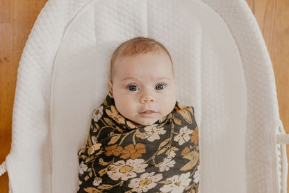 a sweet photo of a little baby wrapped cozily in our thicket flower swaddle