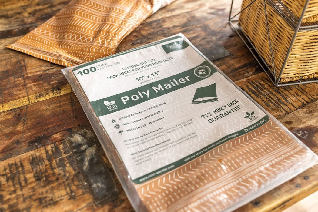 A pack of 100 medium sized polymailers in 10x13 inch size laying on a wooden desk of a small business