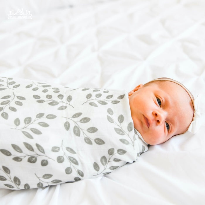 sweet baby girl wrapped like a burrito in her summer swaddle the perfect muslin cotton swaddle for swaddling in the summer