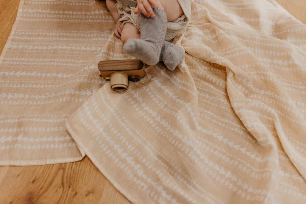 litle baby feet wearing gray socks with the tribal receiving blanket as a photography backdrop