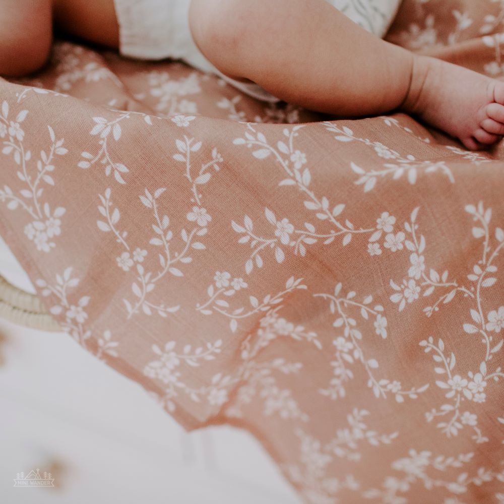 photo of a baby chubby legs while lying down on a mini wander swaddle called Bloom sienna